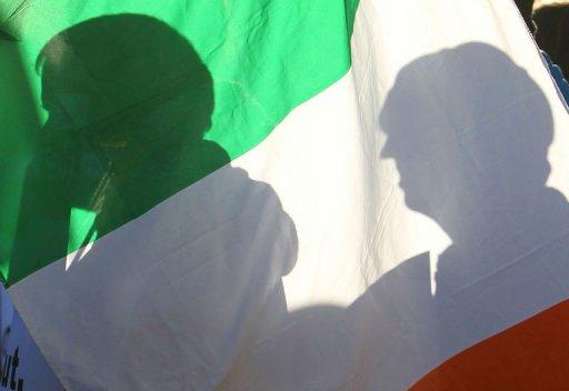 La sombra de unos manifestantes se dibuja en una bandera irlandesa durante una protesta fuera de la sede del Gobierno