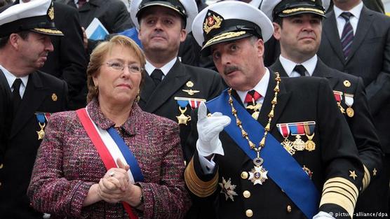 Bachelet escucha un comentario de militar engalanado de medallas