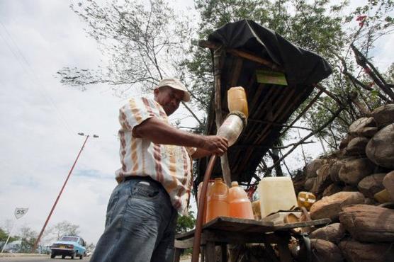 Un hombre facciona gasolina traida de Venezuela