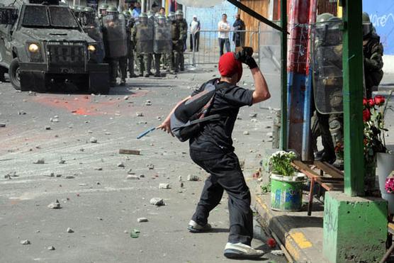 Un encapuchado acciona contra los carabineros, ayer en Santiagode Chile