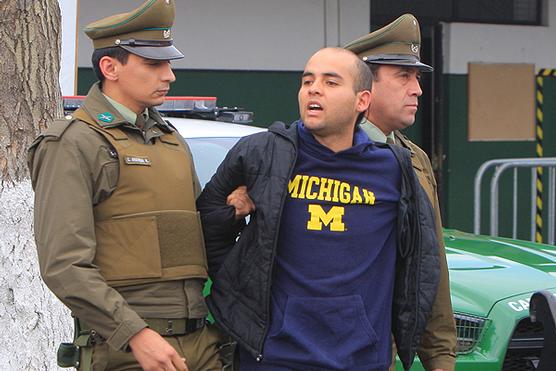Uno de los detenidos es llevado a la Justicia, ayer en Santiago
