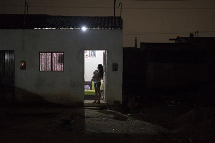Angelica Pereira sostiene a su hija Luiza mientras espera a su marido en su casa de Santa Cruz do Capibaribe, en Pernanbuco