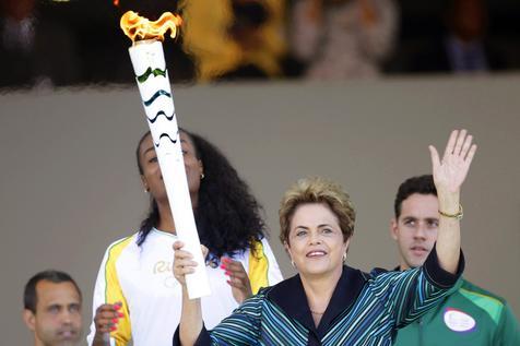 Rousseff y la antorcha olímpica que entregó a la capitana de la selección de voleibol Fabiana Claudino.
