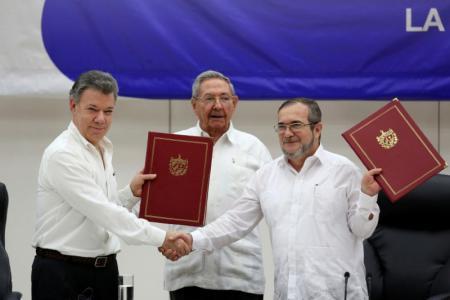Santos se da la mano con el líder de las FARC, Rodrigo Londoño y Raúl Castro