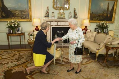 Isabel II saluda a Theresa May al comienzo de su audiencia en el Palacio de Buckingham, ayer