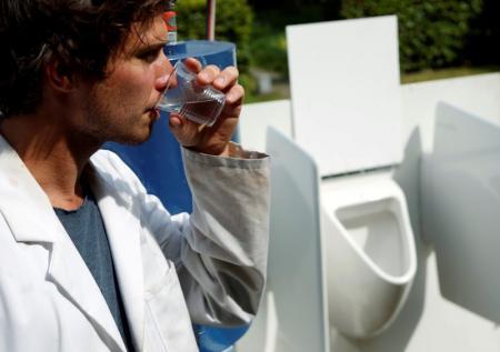El científico Sebastiaan Derese bebe agua de una máquina que transforma la orina en agua potable y fertilizantes.