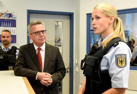 El ministro del Interior de Alemania, Thomas de Maiziere, habla con la oficial de policía Laura Schaefe