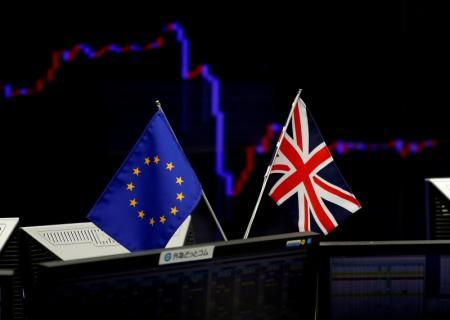 Una bandera británica y una de la Unión Europea frente a un monitor que muestra la gráfica de fluctuación del yen japonés 