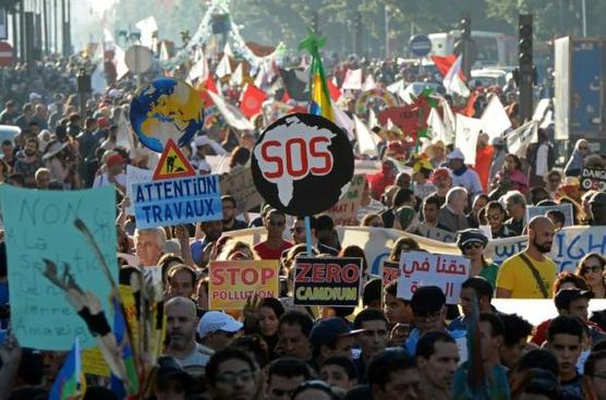 Manifestantes marroquíes e internacionales exhiben pancartas durante una protesta contra el cambio climático 