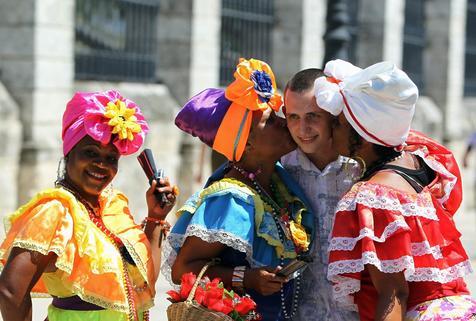 Un turista rodeado de cubanas con ropas típicas durante un evento en La Habana
