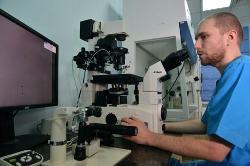 Un laboratorista trabaja con un microscopio