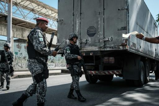 Policías en controles para detectar vehículos robados en un retén frente a una favela