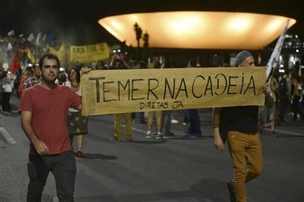 Manifestantes llevan un letrero con la leyenda en portugués "Temer en la cárcel"