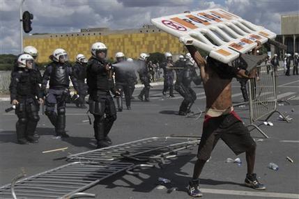 Un manifestante se enfrenta con la policía durante una protesta en contra del gobierno en Brasilia, 