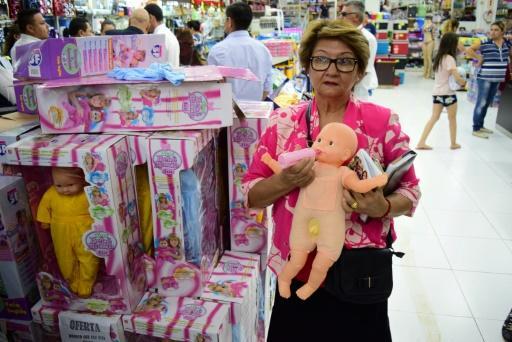 Una mujer posa junto a una de las muñecas con pene, el 9 de enero de 2018 en una tienda de Ciudad del Este, Paraguay
