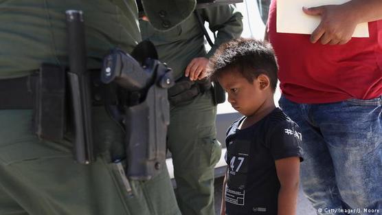 Un niño migrante rodeado de policías armados