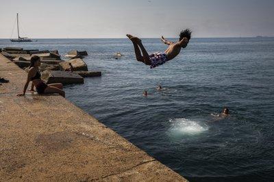 Un niño lanzándose al mar en una playa de Barcelona