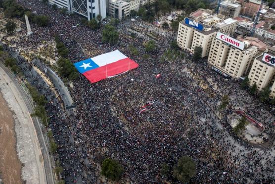 Vista aérea de personas manifestándose con una bandera nacional chilena gigante contra el gobierno de Piñera, ayer en Santiago