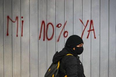 Una mujer camina frente a un grafiti contra el Administradoras de Fondos de Pensiones (AFP) en Santiago