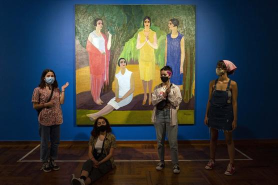 Grupo con tapaboca frente a una pintura de Petrona Viera mientras visitan el Museo Nacional de Artes Visuales en Montevideo