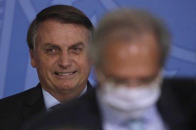 Bolsonaro sonríe detrás de su ministro de Economía Paulo Guedes