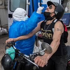 Motociclista se somete a una prueba de PCR para COVID-19 en una instalación de tests frente al Congreso de Uruguay