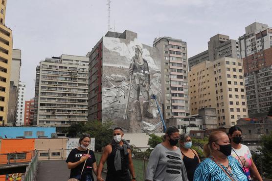 La gente pasa por el mural 'The Forest Brigade' realizado por el artista y activista brasileño Mundano