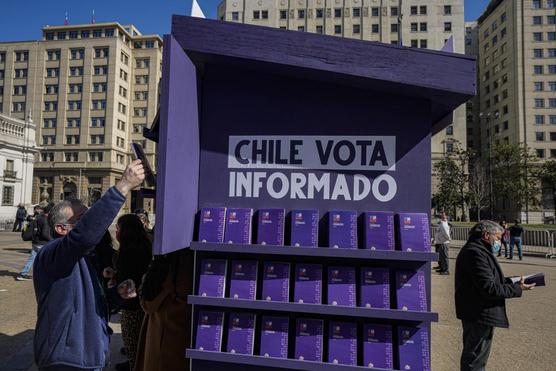 En la vereda  un stand con copias del borrador de la nueva constitución durante el lanzamiento del programa Chile Vota Informado